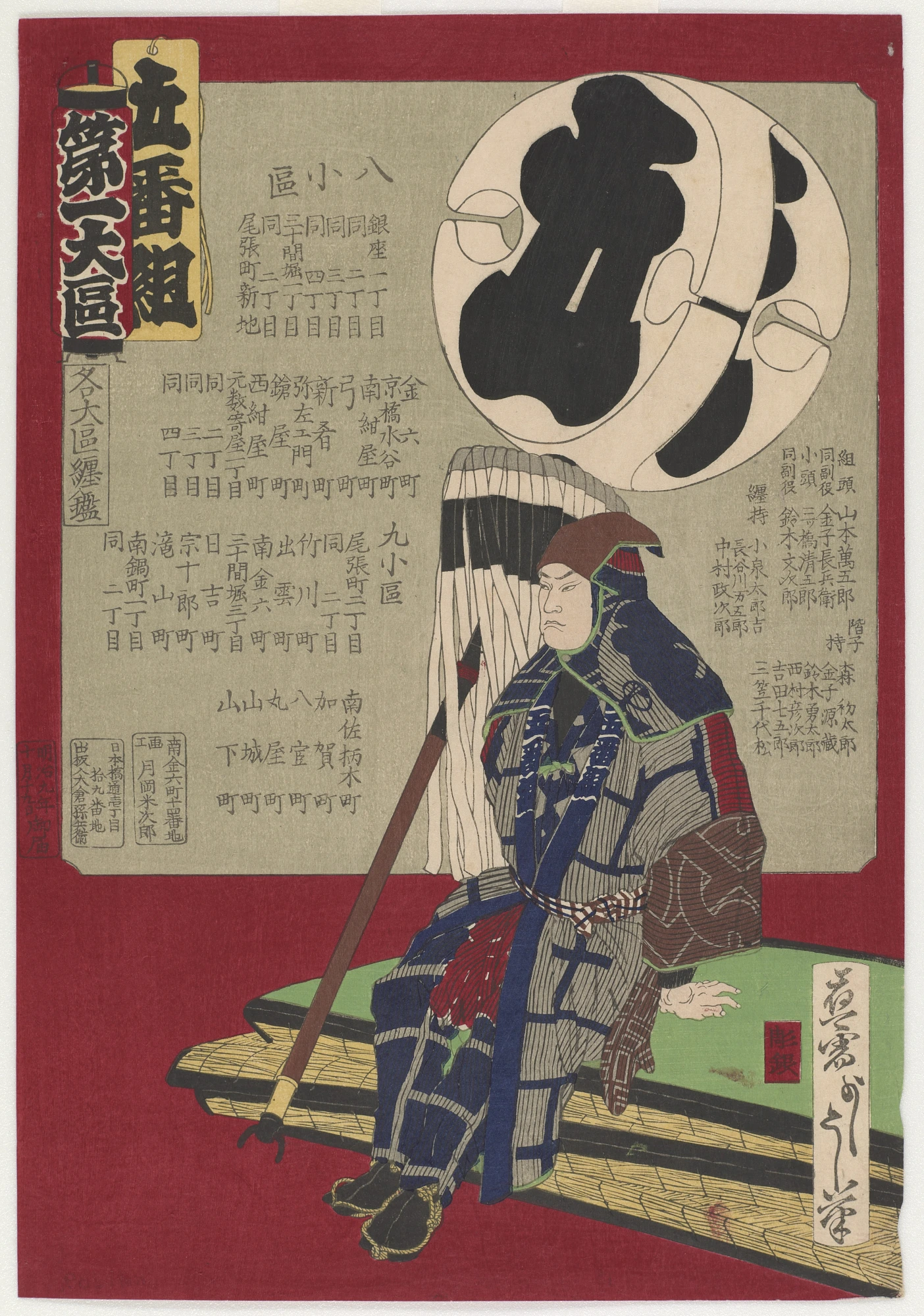 A seated fireman holding the standard for district five.